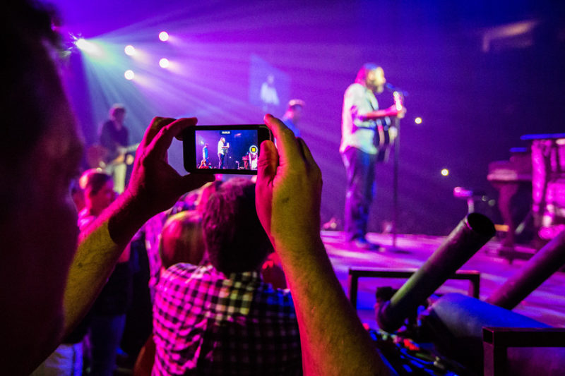 A fan takes a photo of Mac Powell during the Third Day and Friends concert at Infinite Energy Center in Atlanta, Georgia