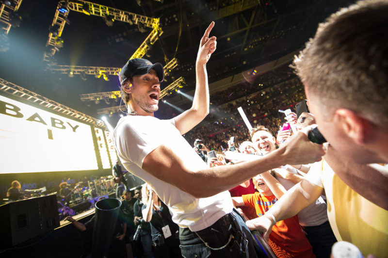 Enrique Iglesias gives a fan the chance to sing during Y100's Jingle Ball in Miami, Florida